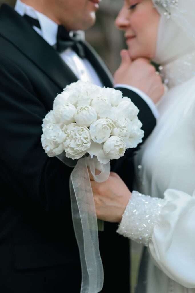 Dettaglio degli sposi e bouquet bianco in una storia di matrimonio ZARART.